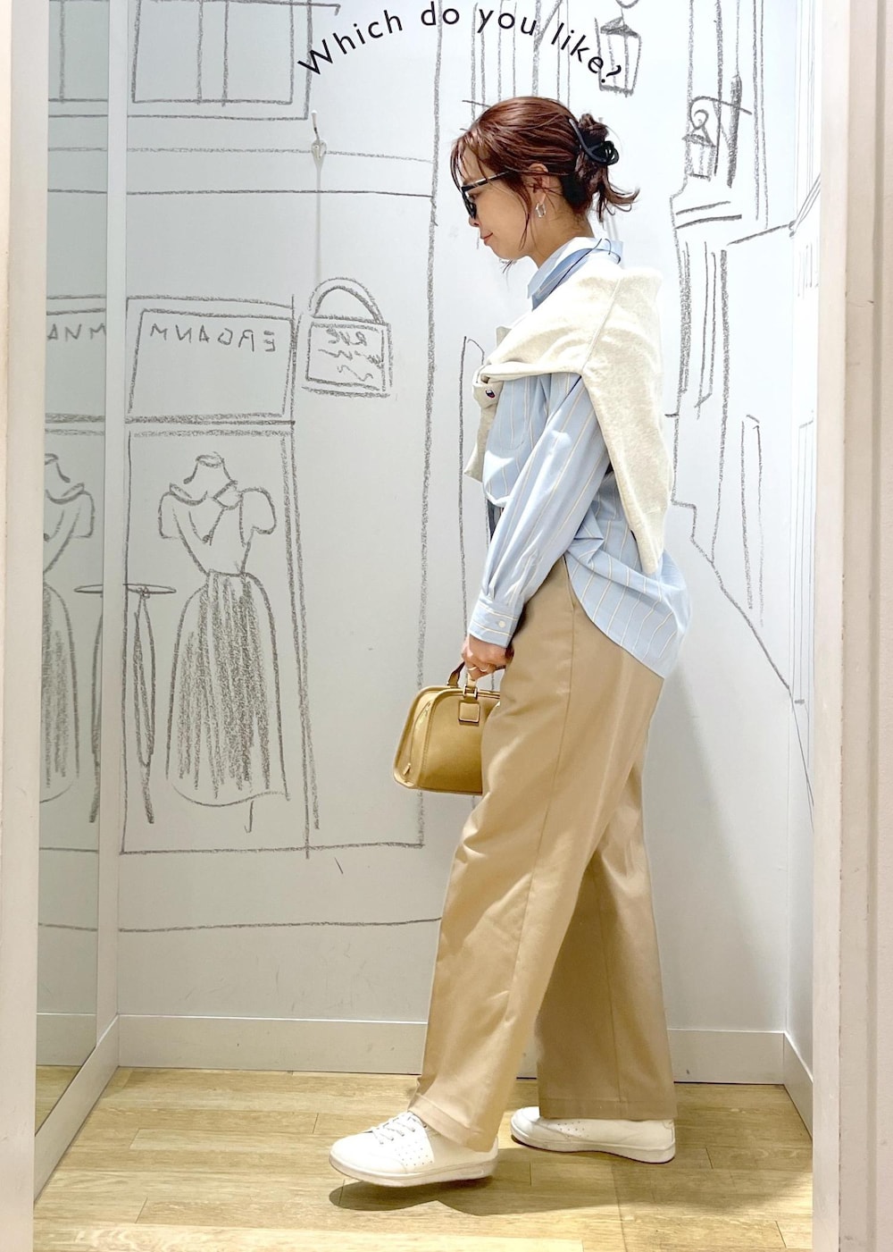 ベージュ系のボストンバッグ、ホワイト系のスウェット、ベージュ系のチノパンツを着用したレディースの春コーディネートの6枚目の写真