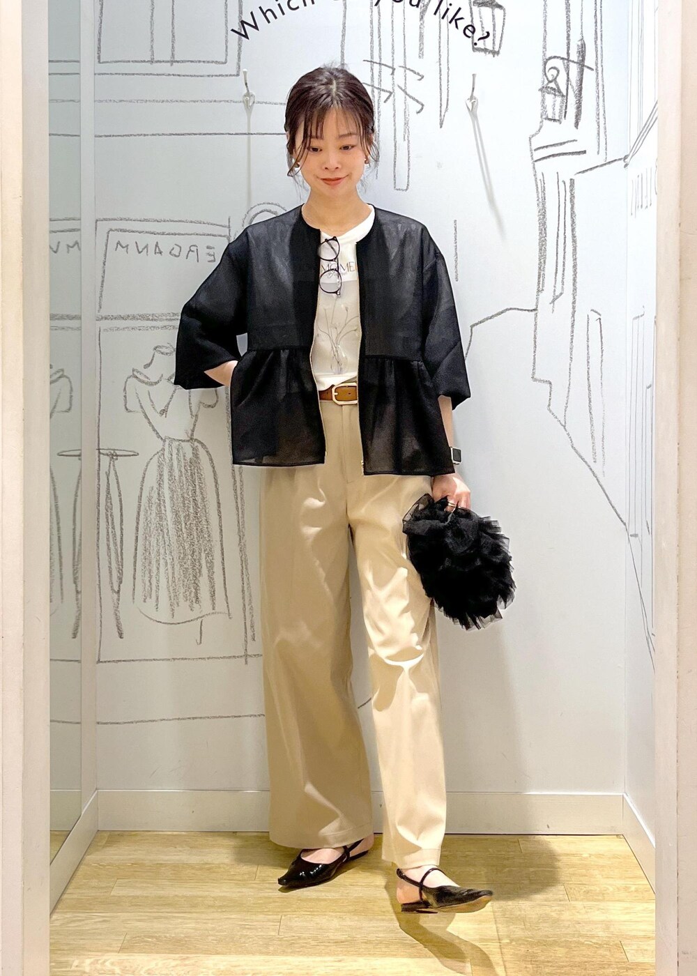 ブラック系のショルダーバッグ、ベージュ系のチノパンツ、ブラック系のブルゾンを着用したレディースの春コーディネートの2枚目の写真