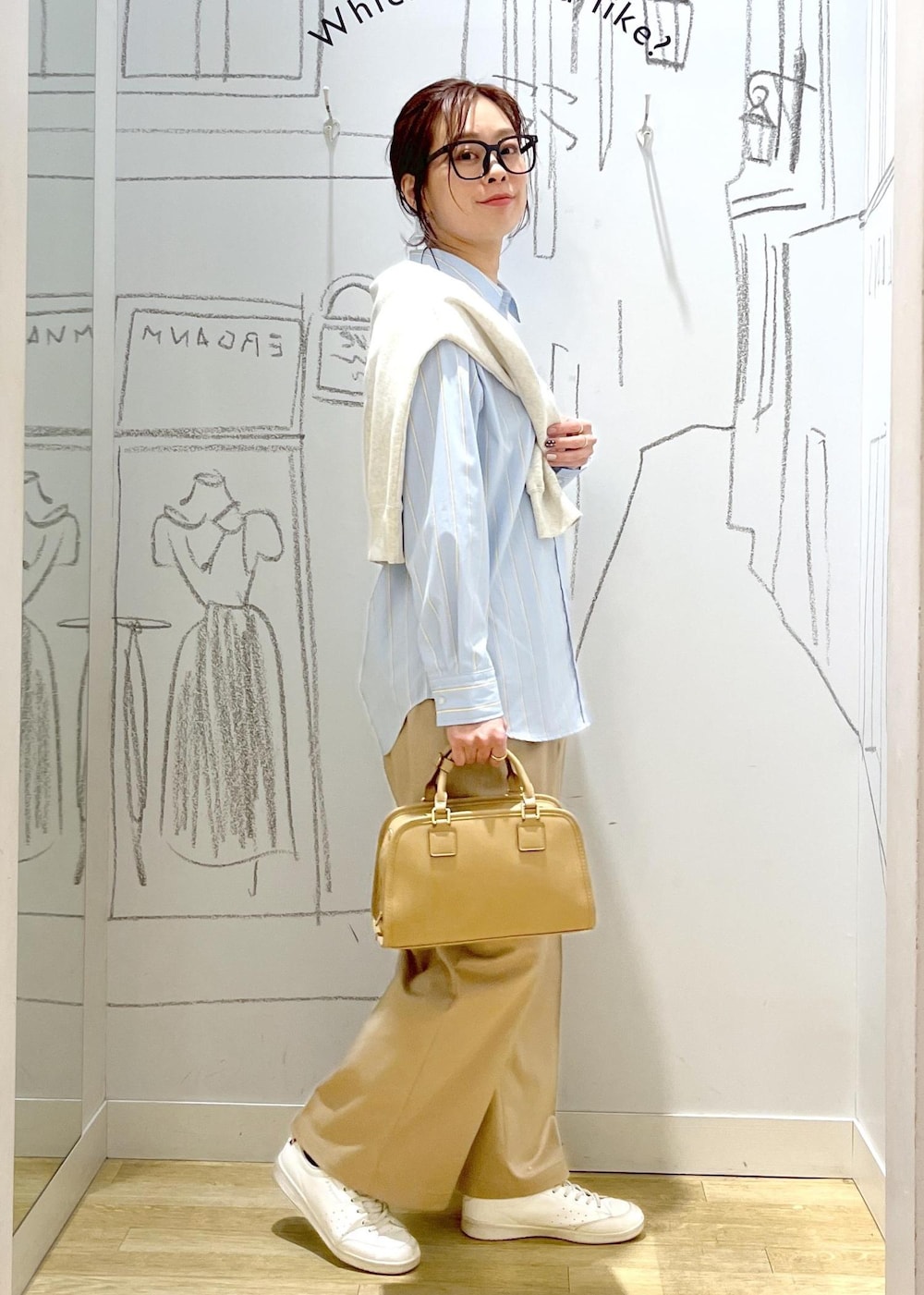 ベージュ系のボストンバッグ、ホワイト系のスウェット、ベージュ系のチノパンツを着用したレディースの春コーディネートの3枚目の写真