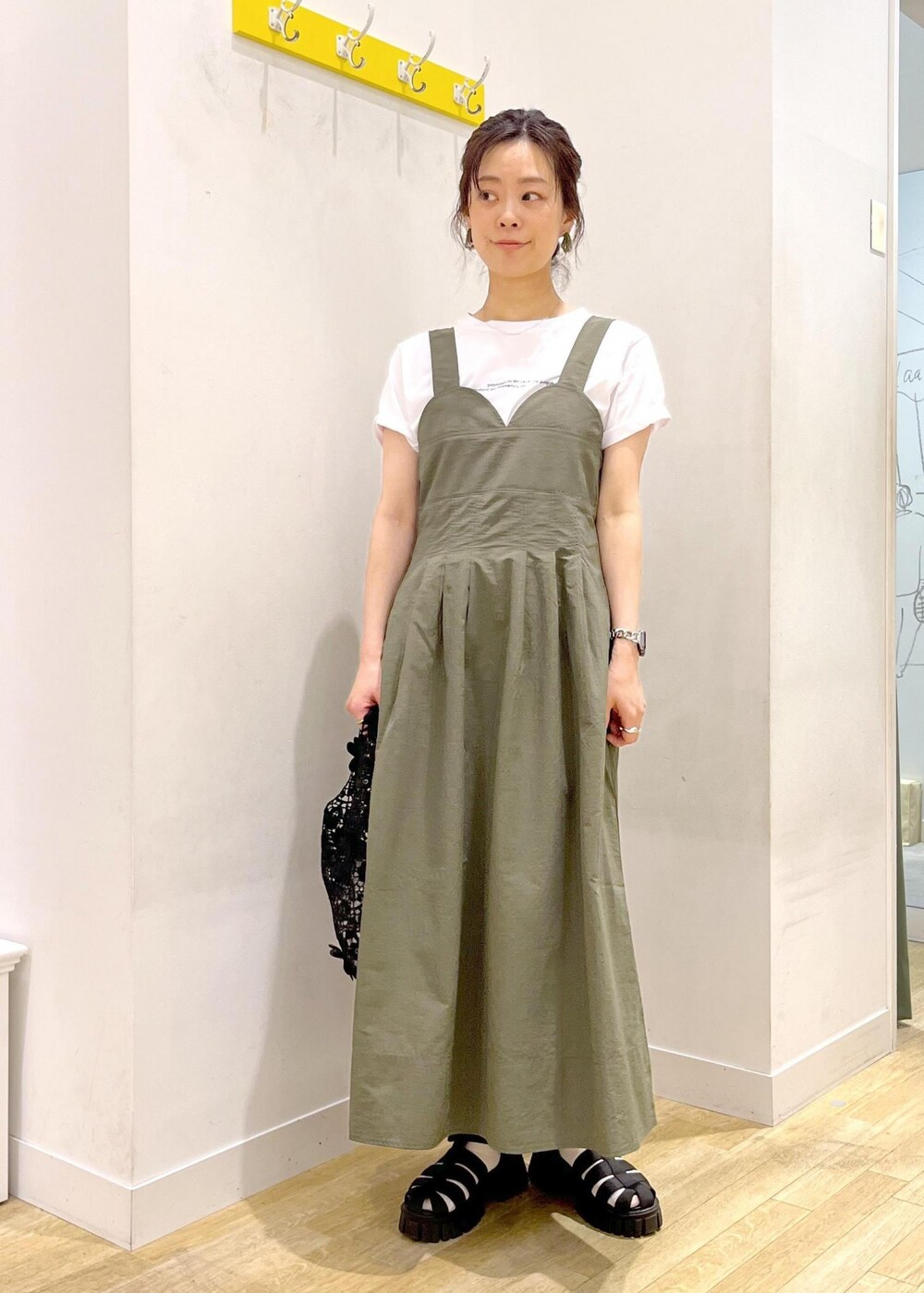 ブラック系のサンダル、グリーン系のワンピース、ブラック系のトートバッグを着用したレディースの春コーディネートの2枚目の写真