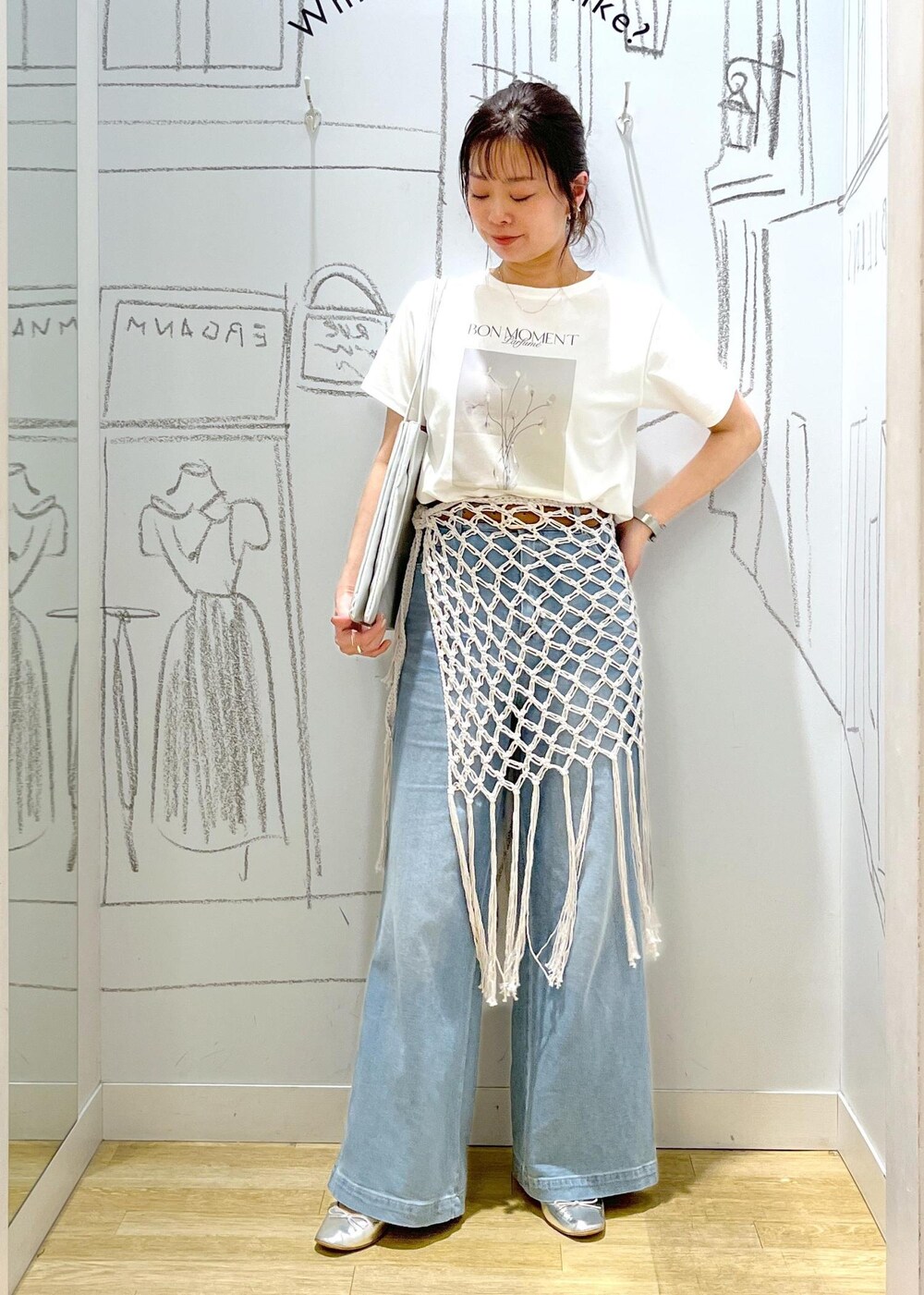 シルバー系のバレエシューズ、シルバー系のトートバッグ、ブルー系のデニムパンツを着用したレディースの春コーディネートの2枚目の写真