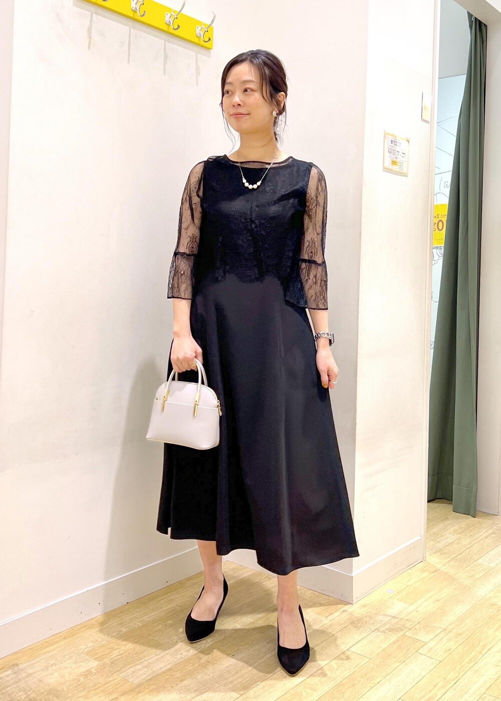 ホワイト系のショルダーバッグ、ブラック系のドレスを着用したレディースの冬コーディネートの2枚目の写真