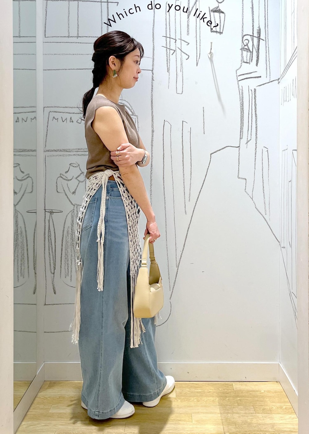 ベージュ系のハンドバッグ、ブルー系のデニムパンツ、ホワイト系のスカートを着用したレディースの春コーディネートの5枚目の写真