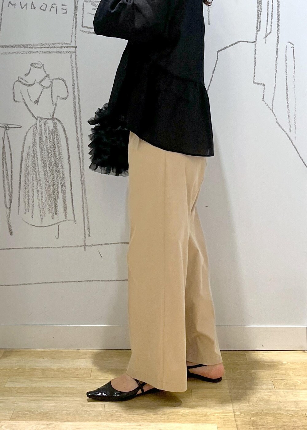 ブラック系のショルダーバッグ、ベージュ系のチノパンツ、ブラック系のブルゾンを着用したレディースの春コーディネートの8枚目の写真