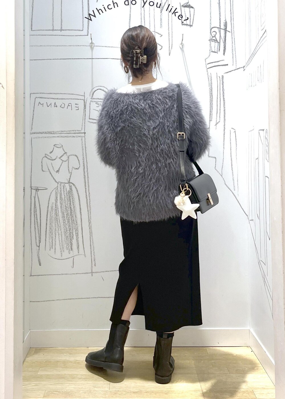 ブラック系のショルダーバッグ、ブラック系のスカート、ホワイト系のTシャツ/カットソーを着用したレディースの冬コーディネートの4枚目の写真