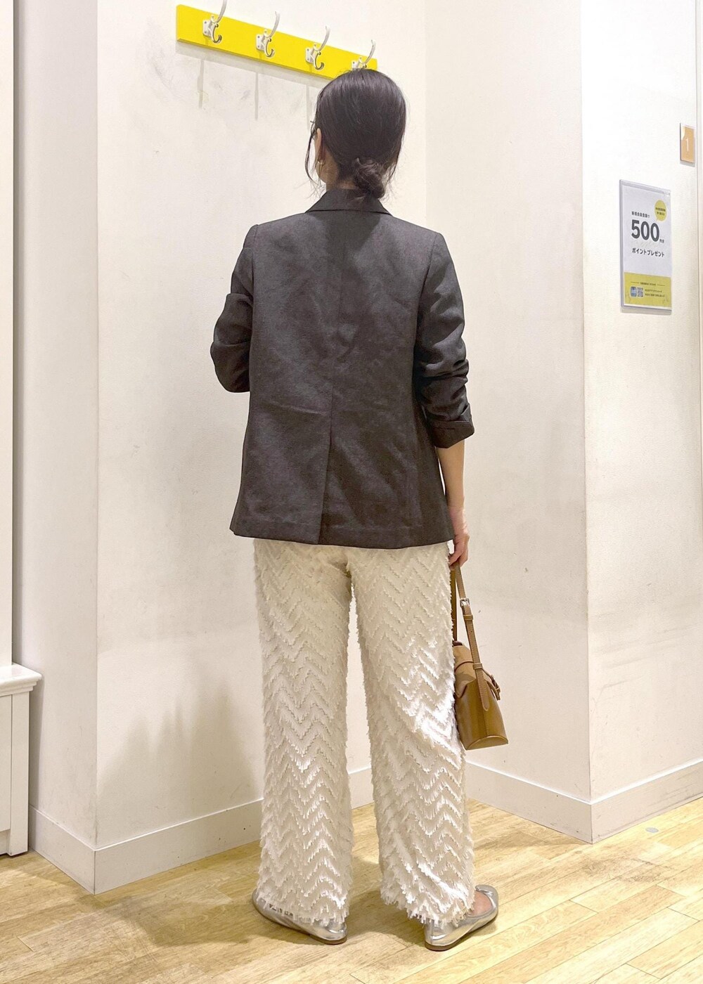 ブラウン系のテーラードジャケット、ブラウン系のショルダーバッグ、グレー系のTシャツ/カットソーを着用したレディースの秋コーディネートの6枚目の写真