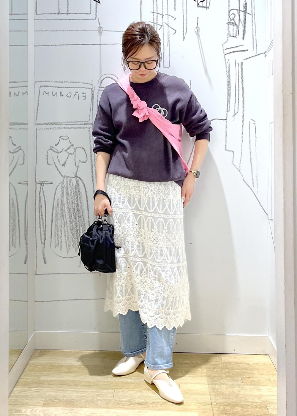 グレー系のニット/セーター、ブルー系のデニムパンツ、ホワイト系のワンピースを着用したレディースの春コーディネートの2枚目の写真