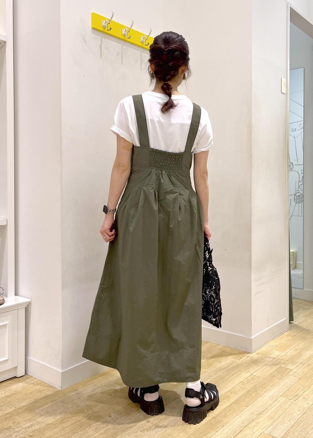 ブラック系のサンダル、グリーン系のワンピース、ブラック系のトートバッグを着用したレディースの春コーディネートの4枚目の写真