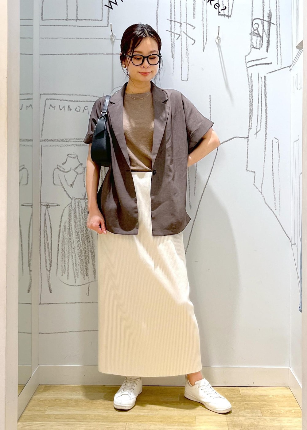 ブラック系のハンドバッグ、ブラウン系のテーラードジャケット、その他のニット/セーターを着用したレディースの夏コーディネートの4枚目の写真