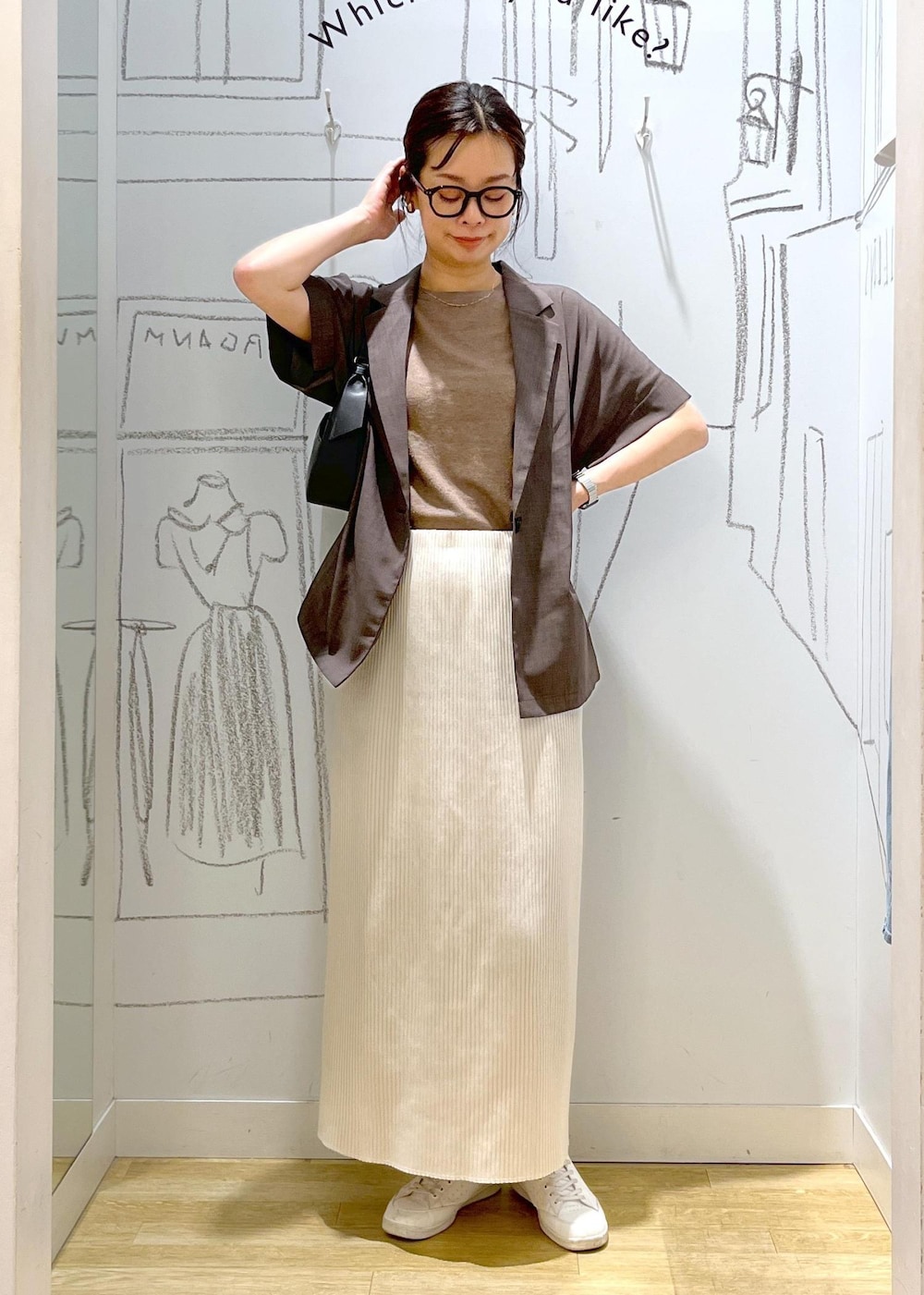 ブラック系のハンドバッグ、ブラウン系のテーラードジャケット、その他のニット/セーターを着用したレディースの夏コーディネートの2枚目の写真