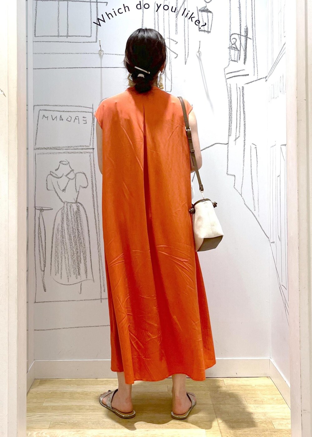 ブラウン系のトートバッグ、オレンジ系のワンピースを着用したレディースの夏コーディネートの5枚目の写真