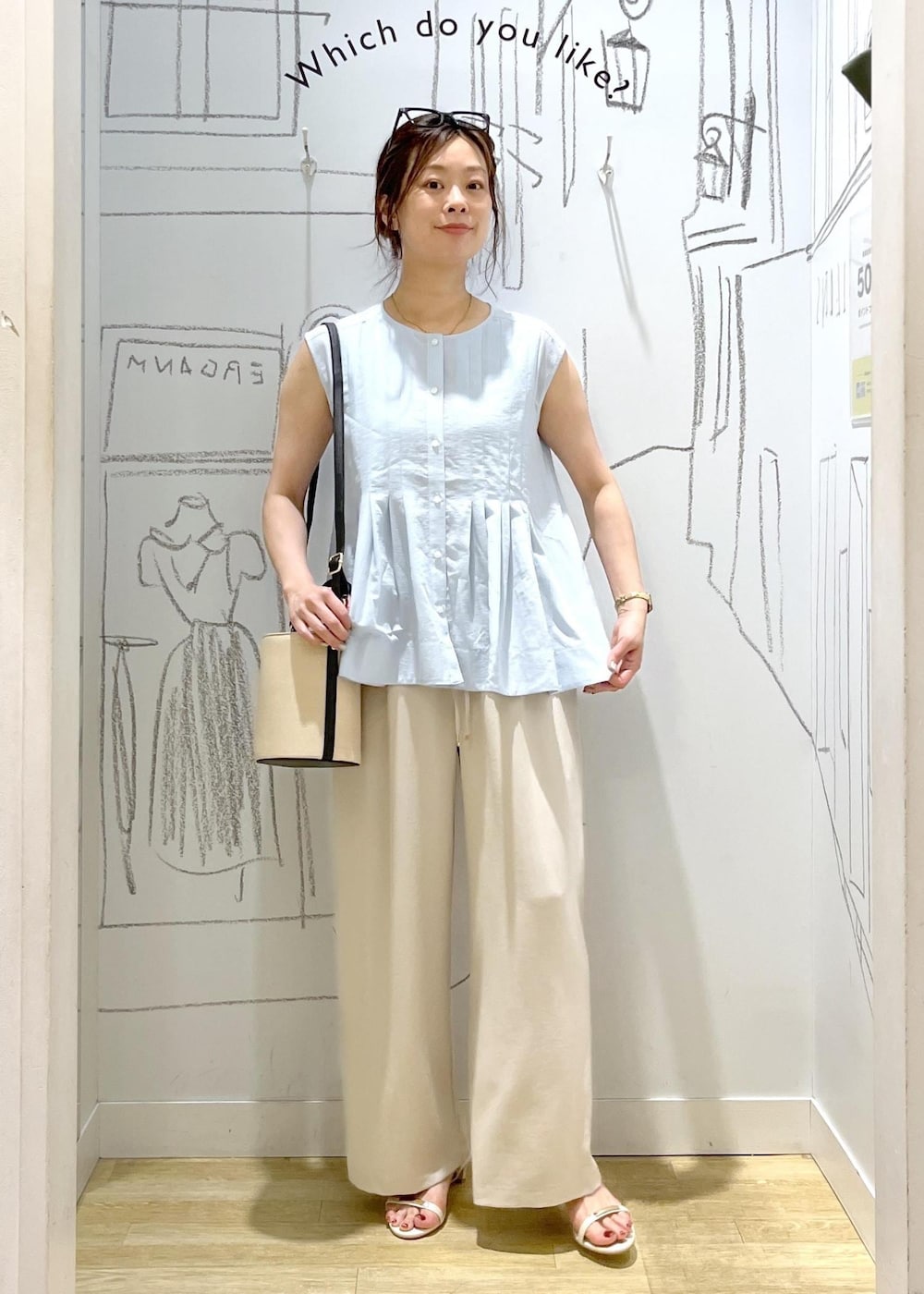 ホワイト系のサンダル、ベージュ系のその他パンツ、ブラック系のハンドバッグを着用したレディースの夏コーディネートの3枚目の写真