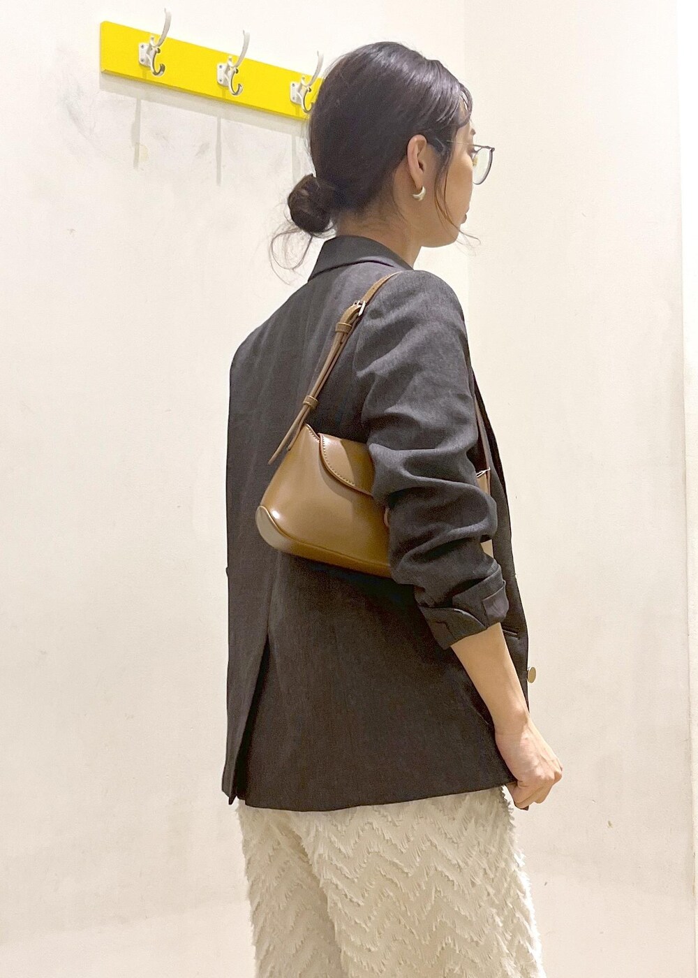 ブラウン系のテーラードジャケット、ブラウン系のショルダーバッグ、グレー系のTシャツ/カットソーを着用したレディースの秋コーディネートの7枚目の写真