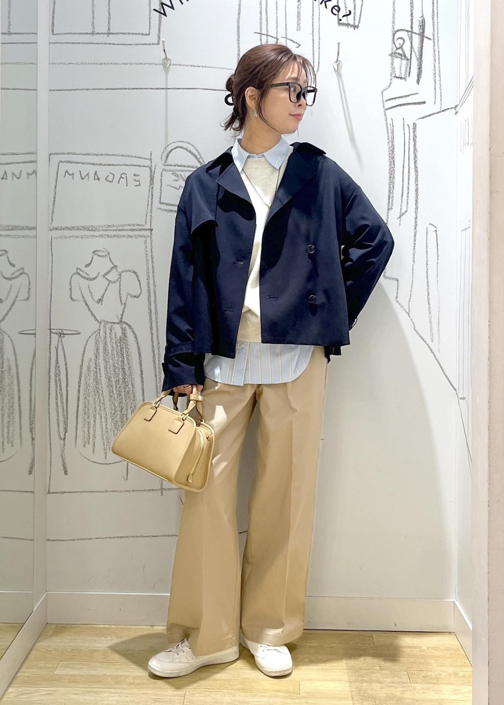 ベージュ系のボストンバッグ、ホワイト系のスウェット、ベージュ系のチノパンツを着用したレディースの春コーディネートの6枚目の写真