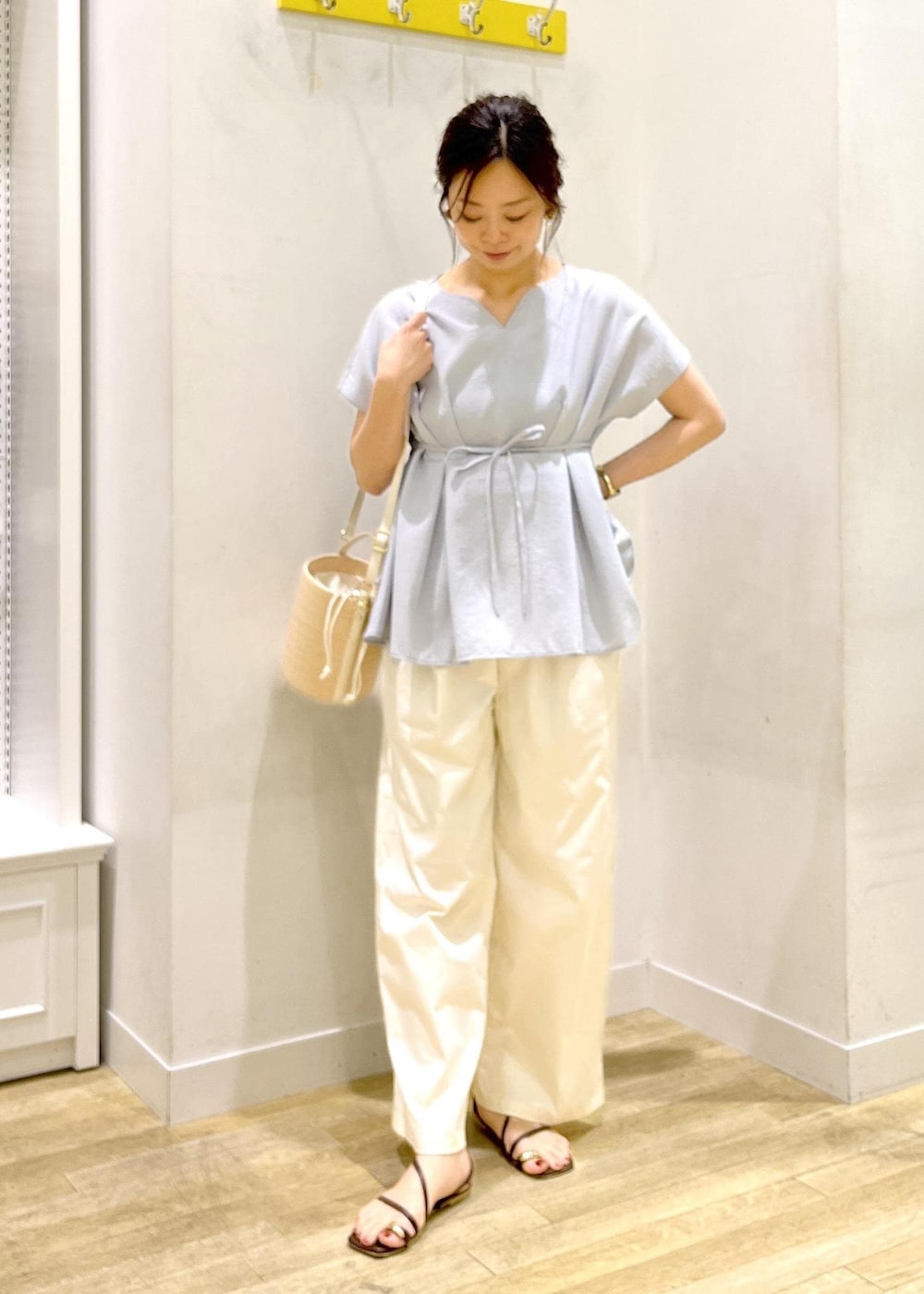 ブルー系のシャツ/ブラウス、ホワイト系のチノパンツ、ホワイト系のハンドバッグを着用したレディースの夏コーディネートの2枚目の写真