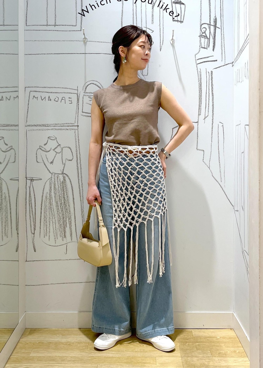 ベージュ系のハンドバッグ、ブルー系のデニムパンツ、ホワイト系のスカートを着用したレディースの春コーディネートの9枚目の写真