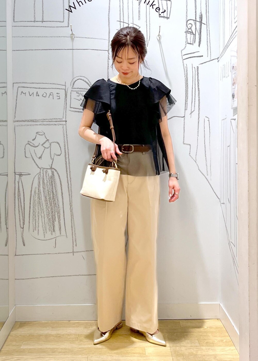 ベージュ系のチノパンツ、ブラウン系のトートバッグ、ブラック系のTシャツ/カットソーを着用したレディースの春コーディネートの5枚目の写真