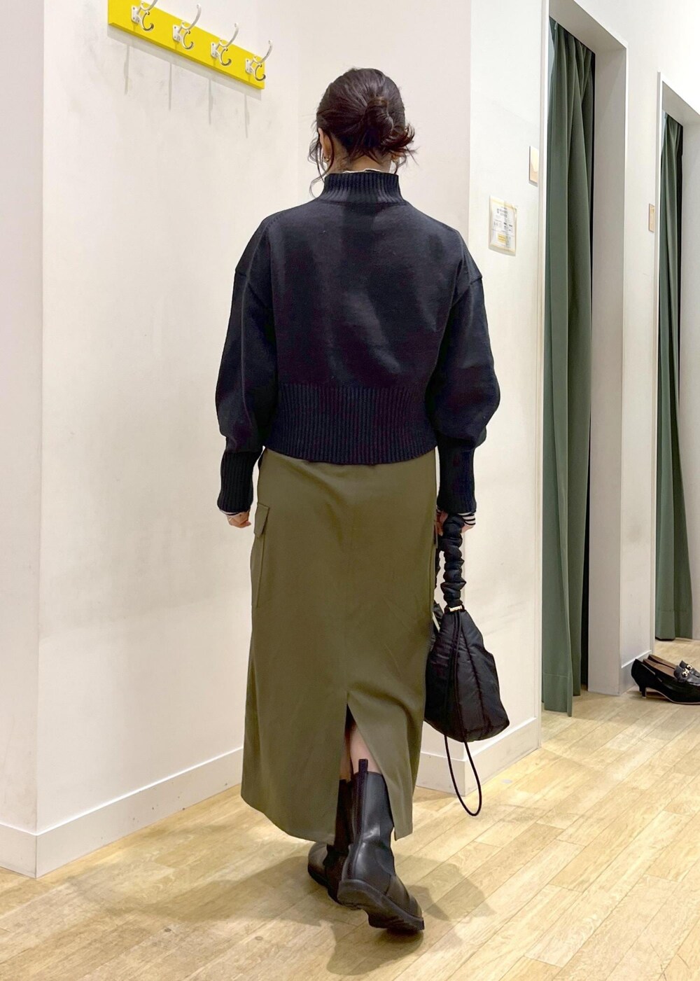 ホワイト系のTシャツ/カットソー、ブラック系のニット/セーター、ブラック系のショルダーバッグを着用したレディースの冬コーディネートの3枚目の写真