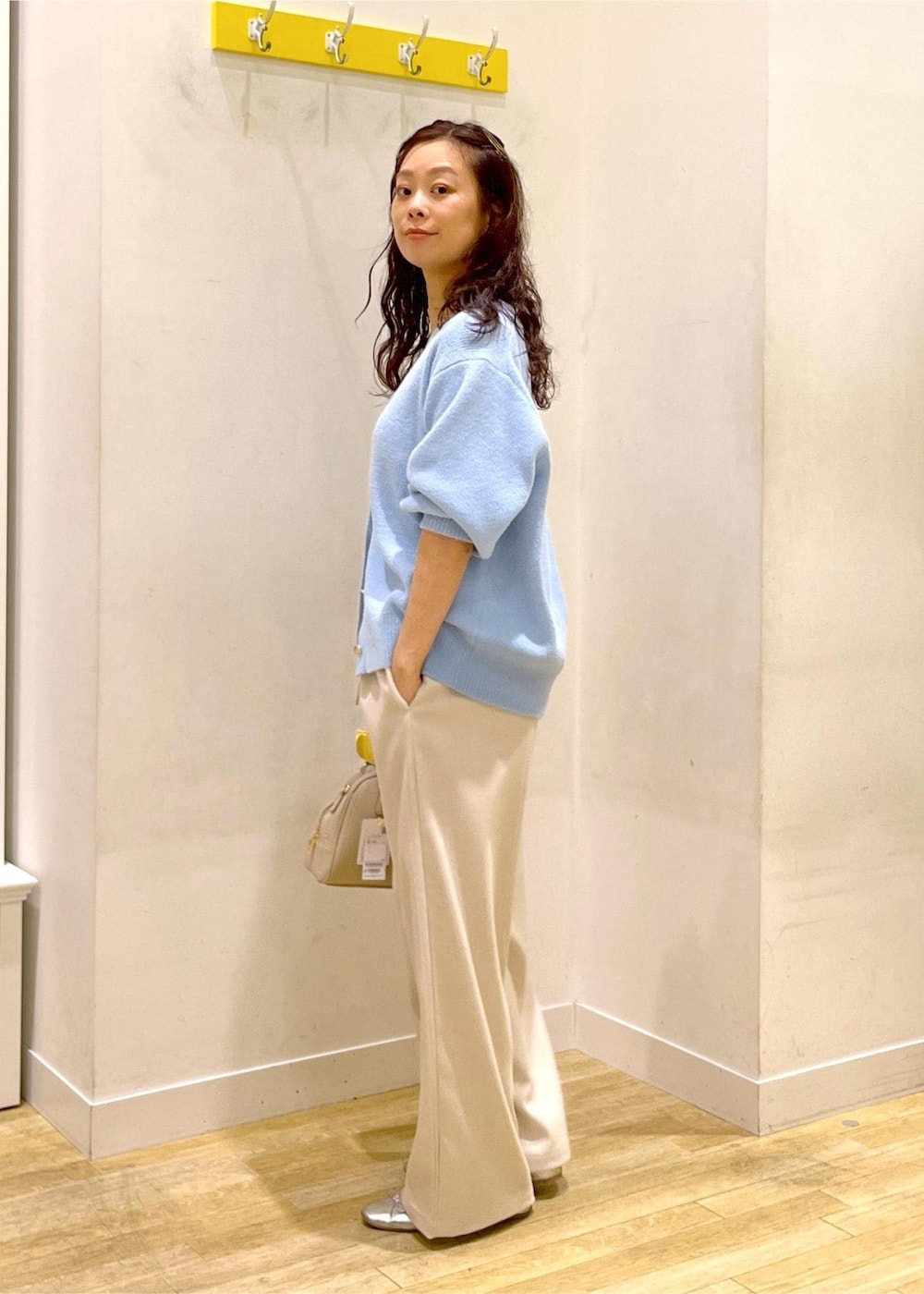 ホワイト系のその他パンツ、ブルー系のカーディガン/ボレロ、ベージュ系のボストンバッグを着用したレディースの秋コーディネートの3枚目の写真