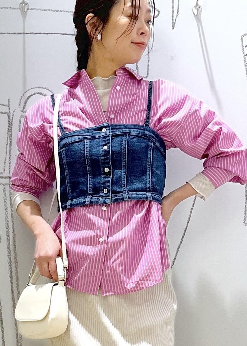 グレー系のスカート、ブルー系のベスト、ピンク系のシャツ/ブラウスを着用したレディースの春コーディネートの7枚目の写真