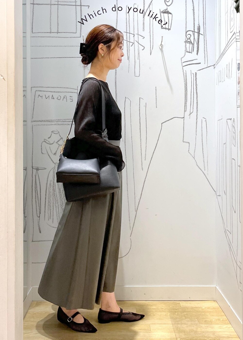 ブラック系のTシャツ/カットソー、ブラック系のショルダーバッグ、グリーン系のスカートを着用したレディースの秋コーディネートの4枚目の写真