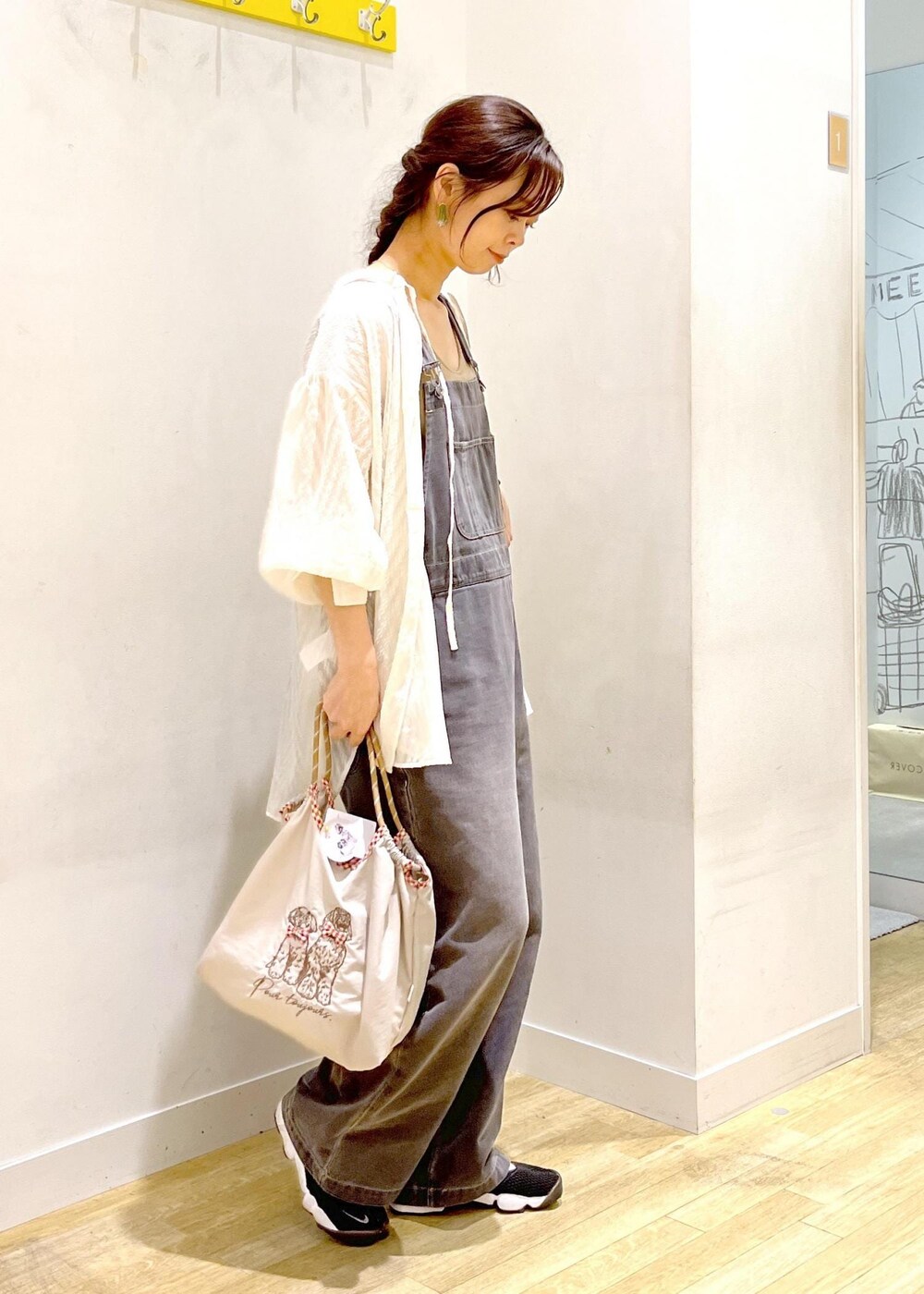 ホワイト系のシャツ/ブラウス、ブラック系のサロペット/オーバーオール、ベージュ系のトートバッグを着用したレディースの秋コーディネートの3枚目の写真