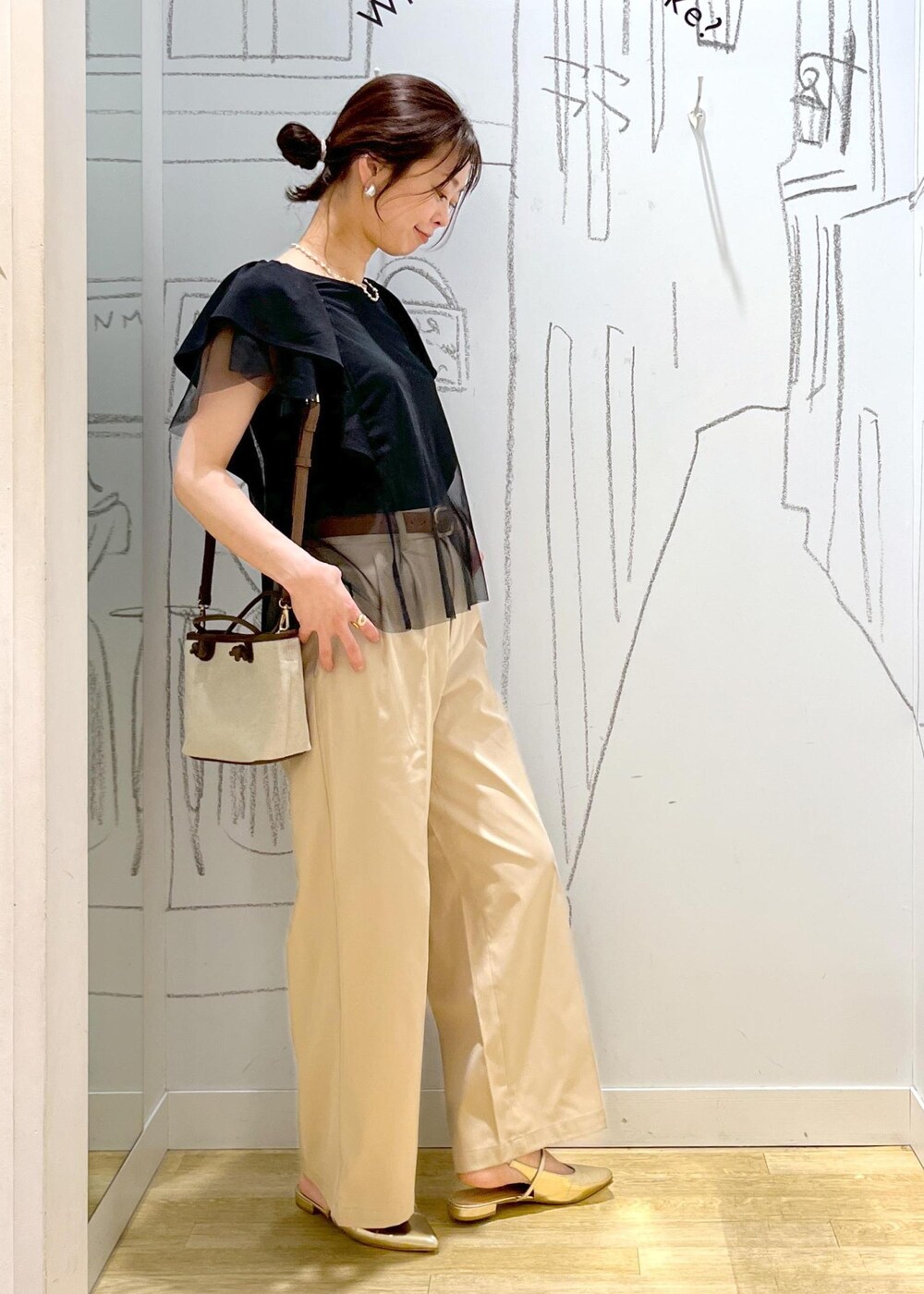 ベージュ系のチノパンツ、ブラウン系のトートバッグ、ブラック系のTシャツ/カットソーを着用したレディースの春コーディネートの8枚目の写真
