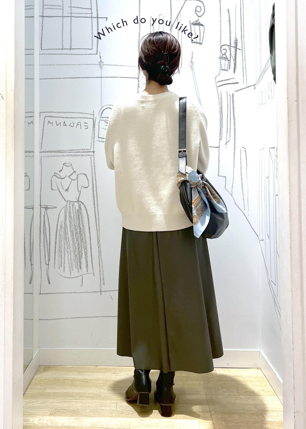 グリーン系のスカート、ホワイト系のカーディガン/ボレロ、ブラック系のショルダーバッグを着用したレディースの秋コーディネートの4枚目の写真