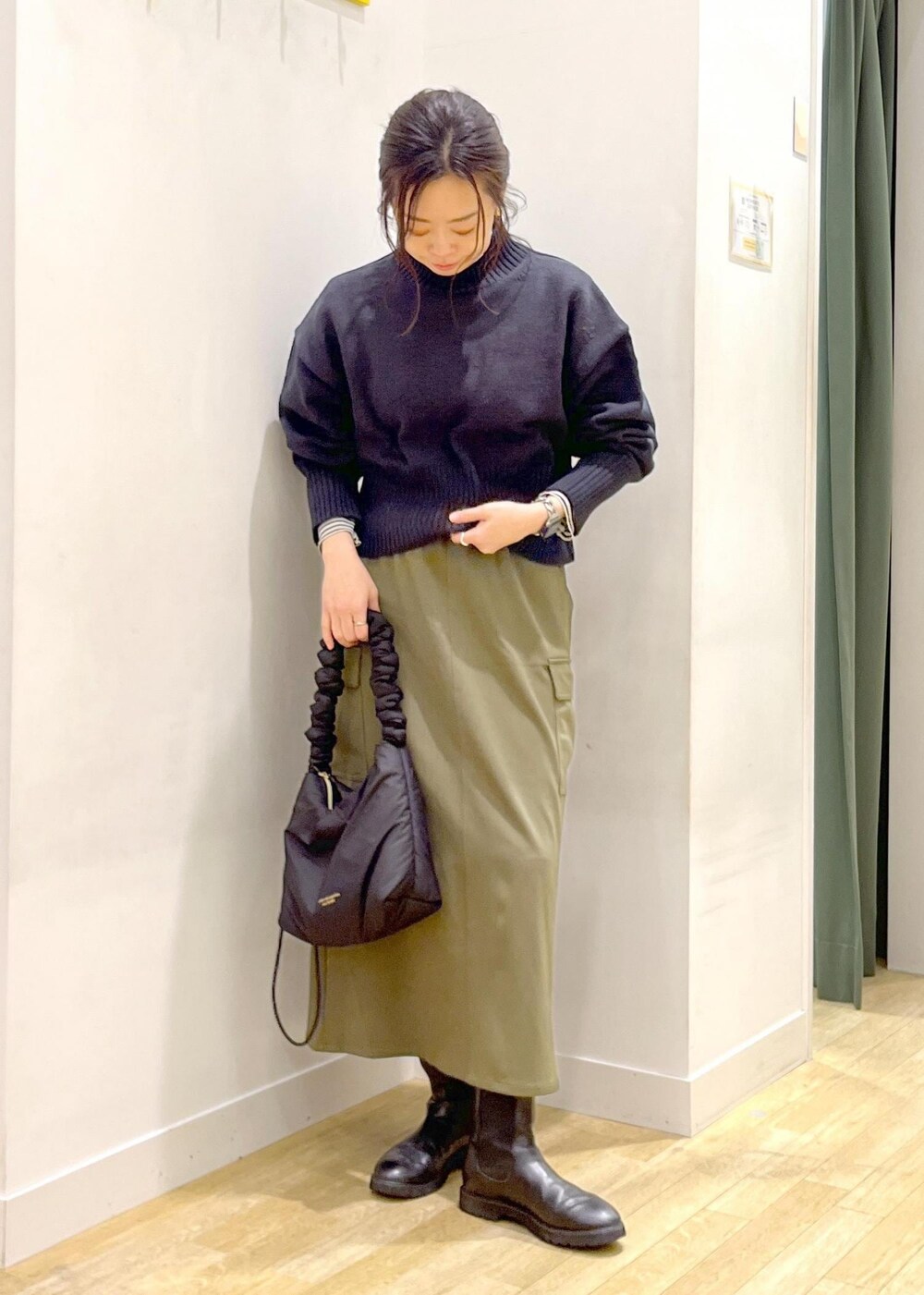 ホワイト系のTシャツ/カットソー、ブラック系のニット/セーター、ブラック系のショルダーバッグを着用したレディースの冬コーディネートの4枚目の写真