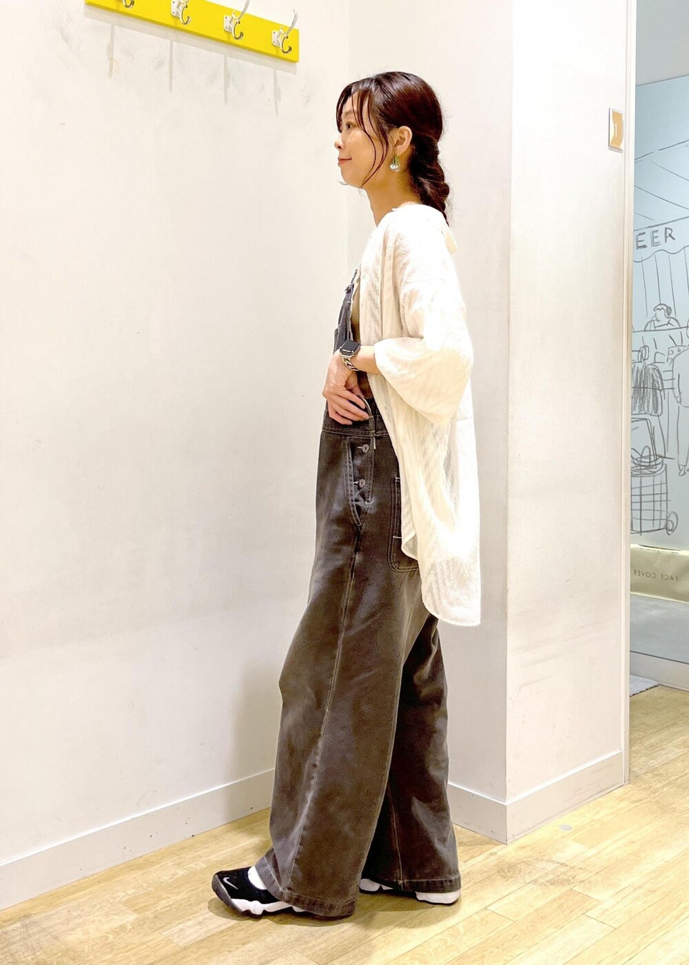 ホワイト系のシャツ/ブラウス、ブラック系のサロペット/オーバーオール、ベージュ系のトートバッグを着用したレディースの秋コーディネートの6枚目の写真