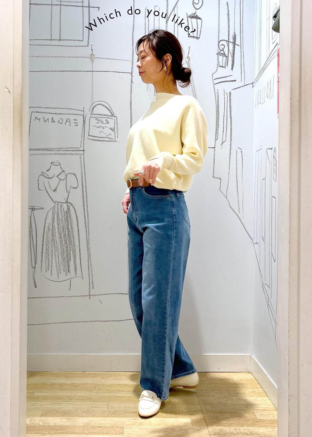 ホワイト系のマウンテンパーカー、シルバー系のショルダーバッグ、ブルー系のデニムパンツを着用したレディースの冬コーディネートの4枚目の写真