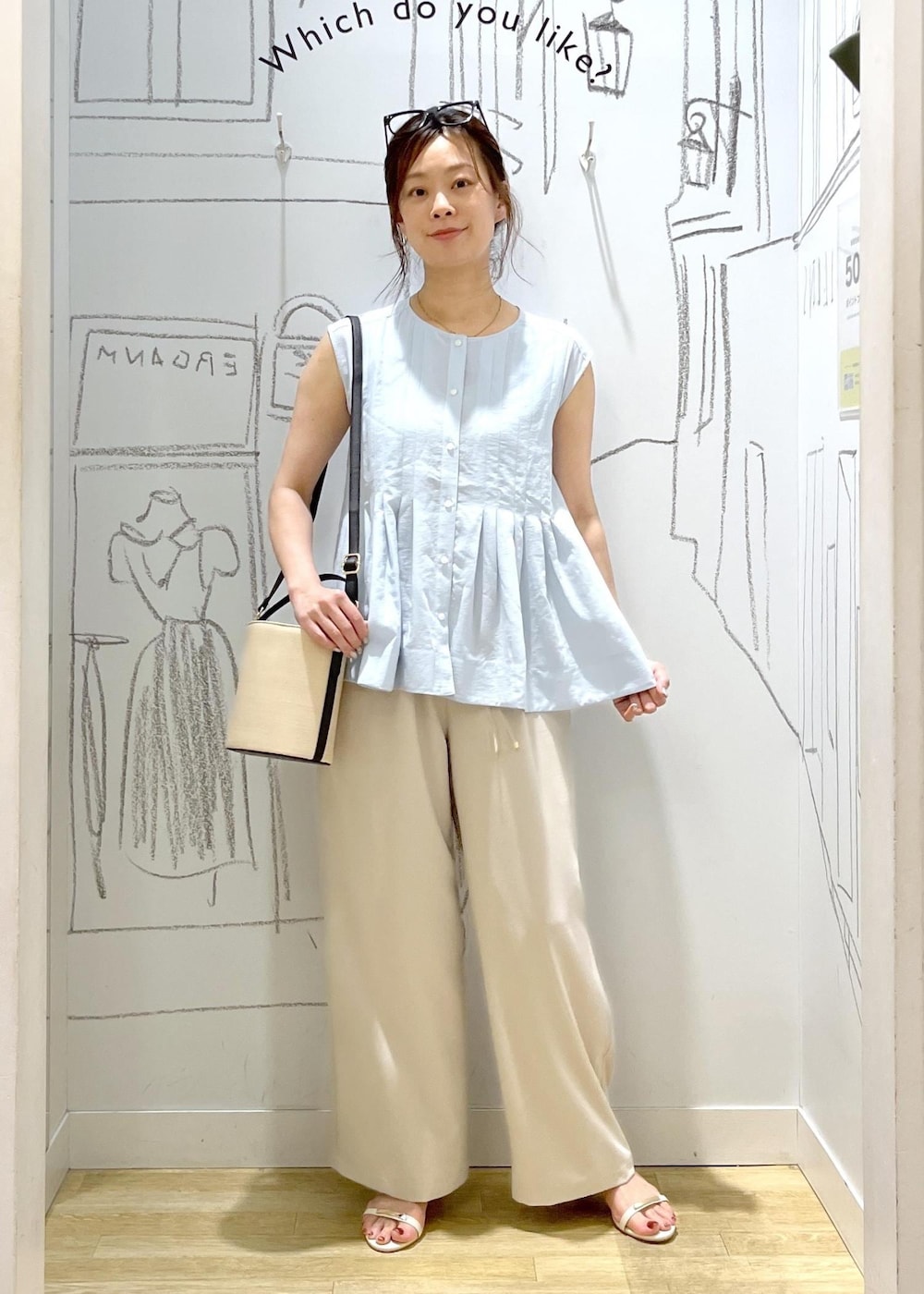 ホワイト系のサンダル、ベージュ系のその他パンツ、ブラック系のハンドバッグを着用したレディースの夏コーディネートの2枚目の写真