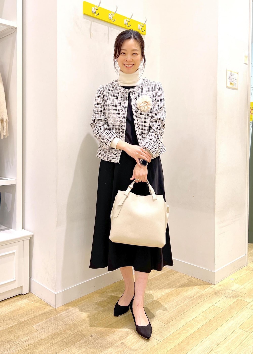 ホワイト系のニット/セーター、ブラック系のドレス、ブラック系のノーカラージャケットを着用したレディースの冬コーディネートの3枚目の写真