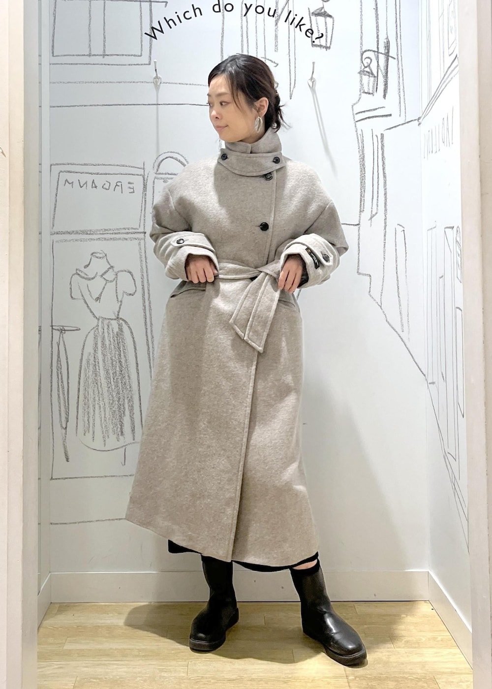 ブラック系のショルダーバッグ、ブラック系のスカート、ベージュ系のチェスターコートを着用したレディースの冬コーディネートの5枚目の写真