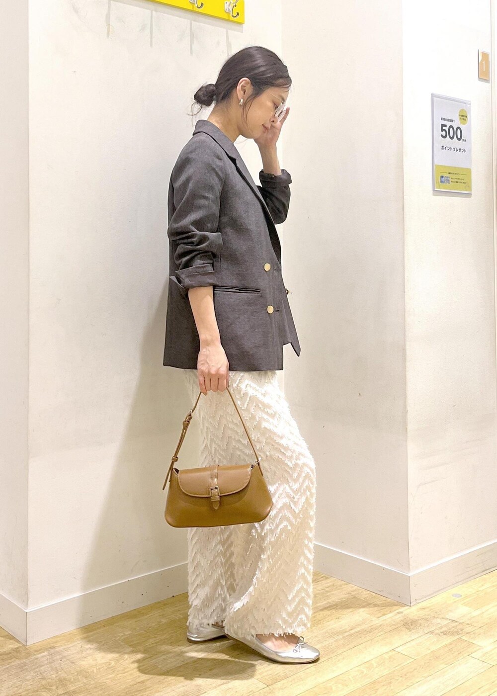 ブラウン系のテーラードジャケット、ブラウン系のショルダーバッグ、グレー系のTシャツ/カットソーを着用したレディースの秋コーディネートの5枚目の写真