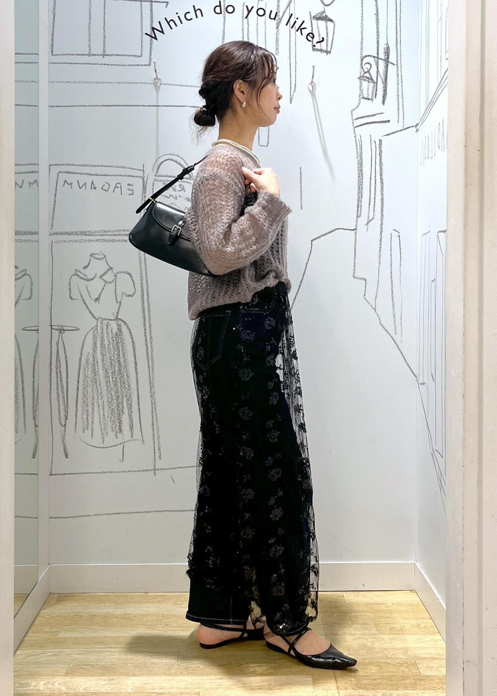 ブラック系のスカート、ブラウン系のニット/セーター、ブラック系のショルダーバッグを着用したレディースの秋コーディネートの3枚目の写真