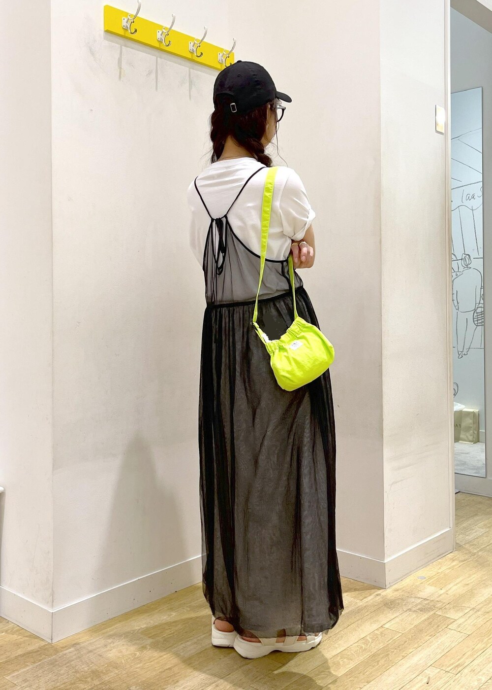 グレー系のワンピース、グリーン系のショルダーバッグ、グレー系のスカートを着用したレディースの春コーディネートの3枚目の写真