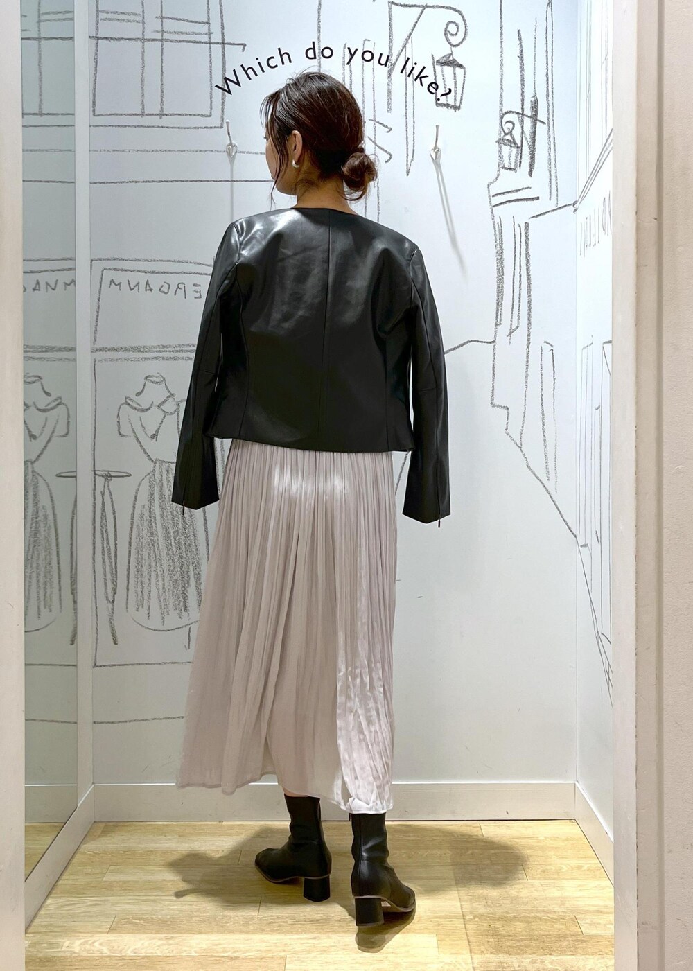 ブラック系のノーカラージャケット、ブラック系のブーツ、シルバー系のショルダーバッグを着用したレディースの冬コーディネートの7枚目の写真