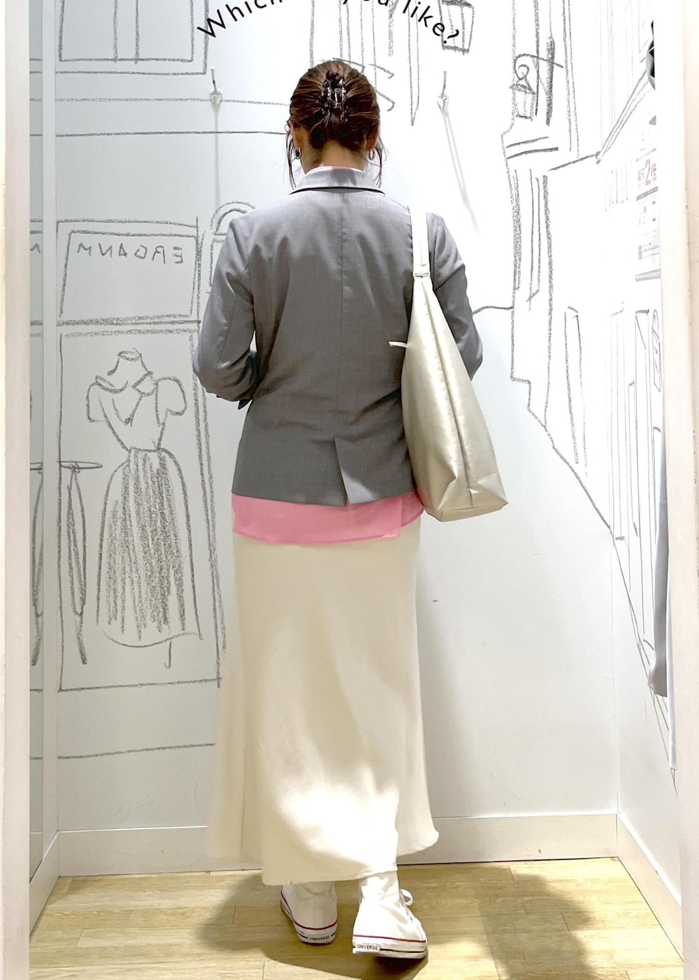 シルバー系のトートバッグ、グレー系のベスト、ホワイト系のスカートを着用したレディースの春コーディネートの6枚目の写真