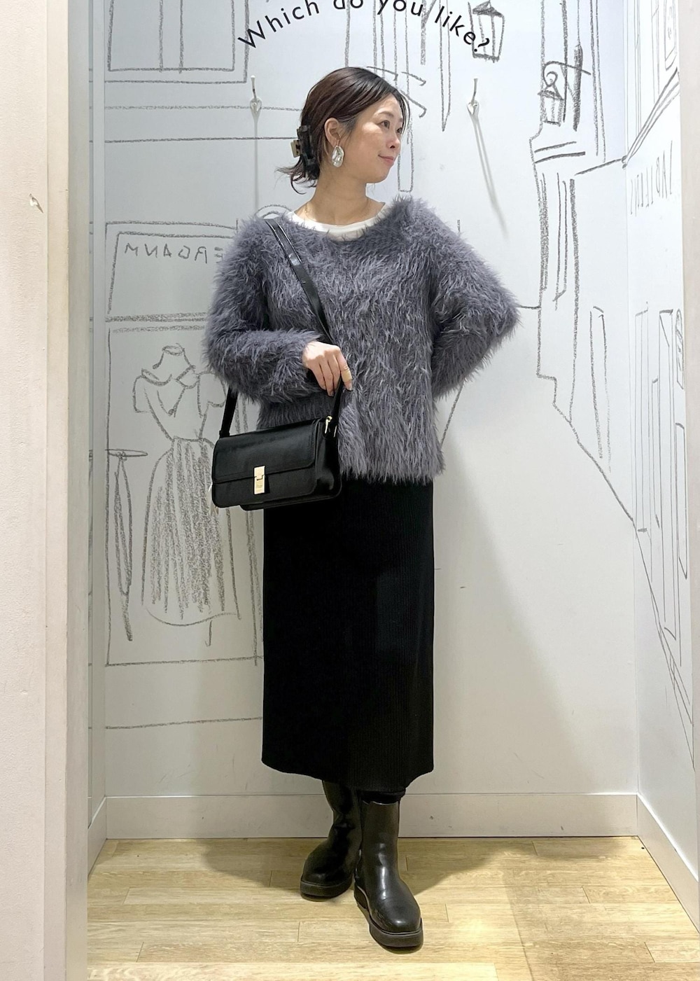 ブラック系のショルダーバッグ、ブラック系のスカート、ベージュ系のチェスターコートを着用したレディースの冬コーディネートの9枚目の写真