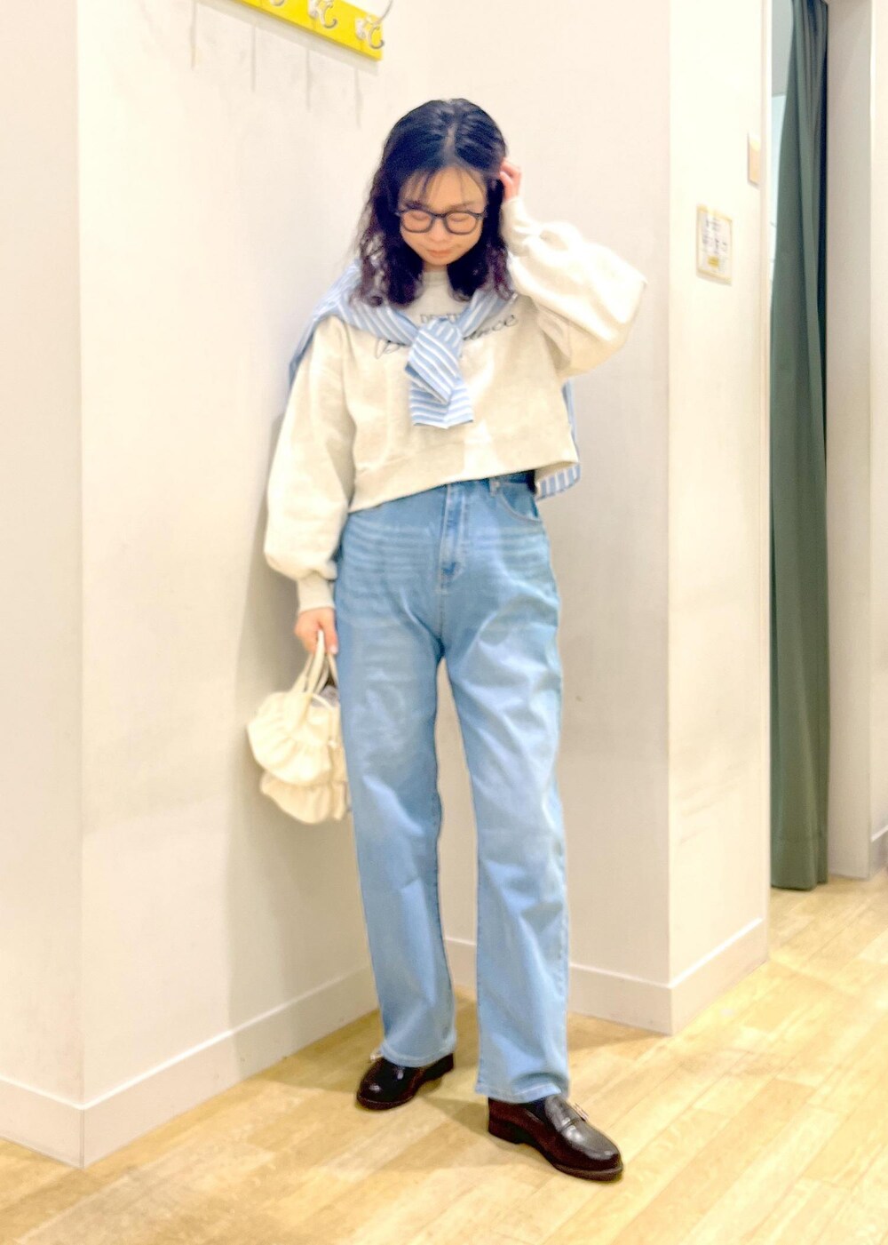 ホワイト系のショルダーバッグ、ブラック系のローファー、グレー系のスウェットを着用したレディースの冬コーディネートの4枚目の写真