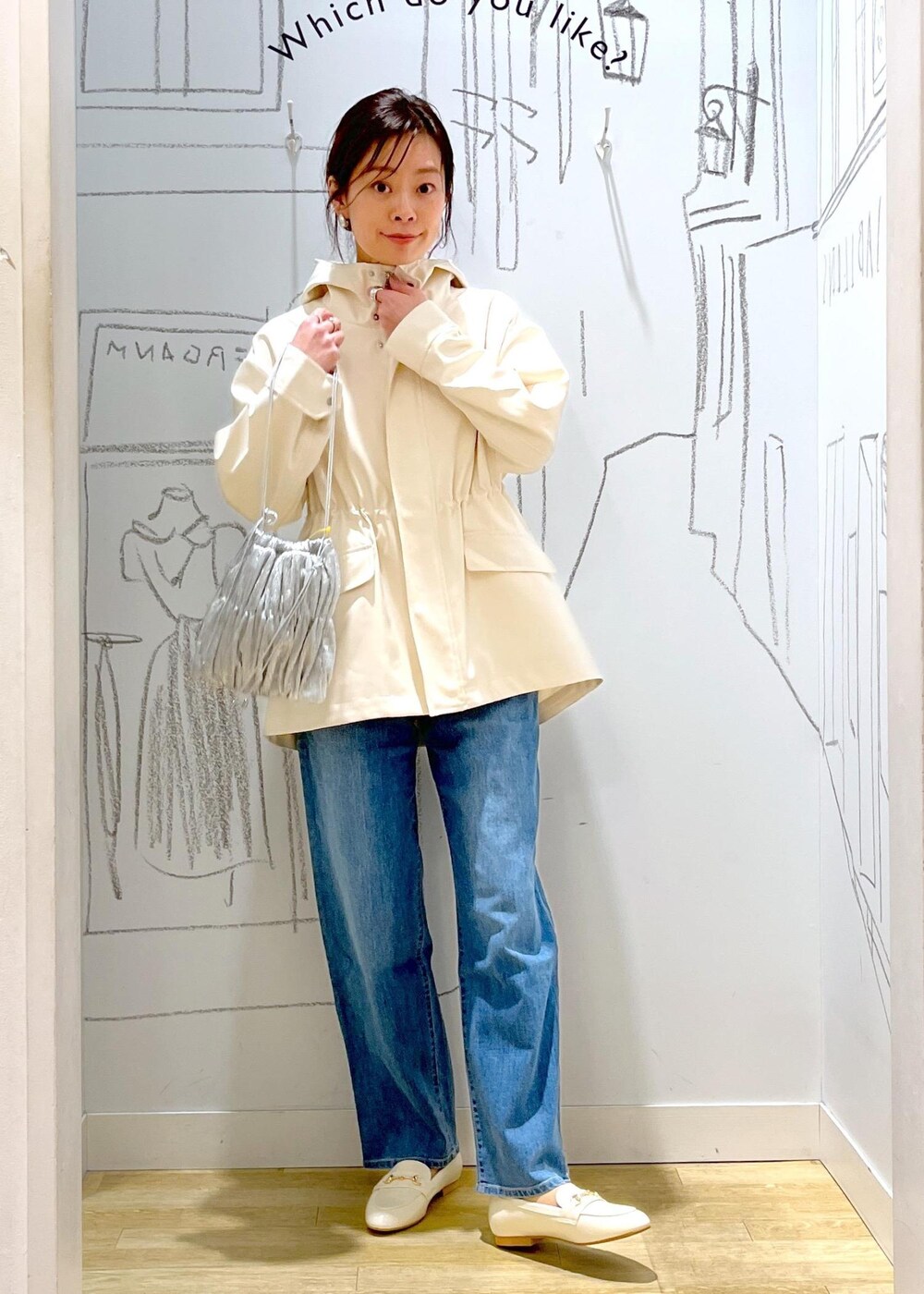 ホワイト系のマウンテンパーカー、シルバー系のショルダーバッグ、ブルー系のデニムパンツを着用したレディースの冬コーディネートの8枚目の写真