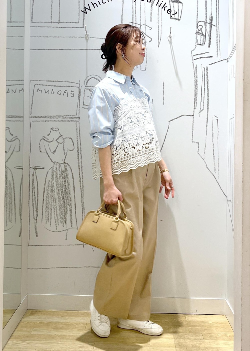 ベージュ系のボストンバッグ、ベージュ系のチノパンツ、ブルー系のシャツ/ブラウスを着用したレディースの春コーディネートの3枚目の写真