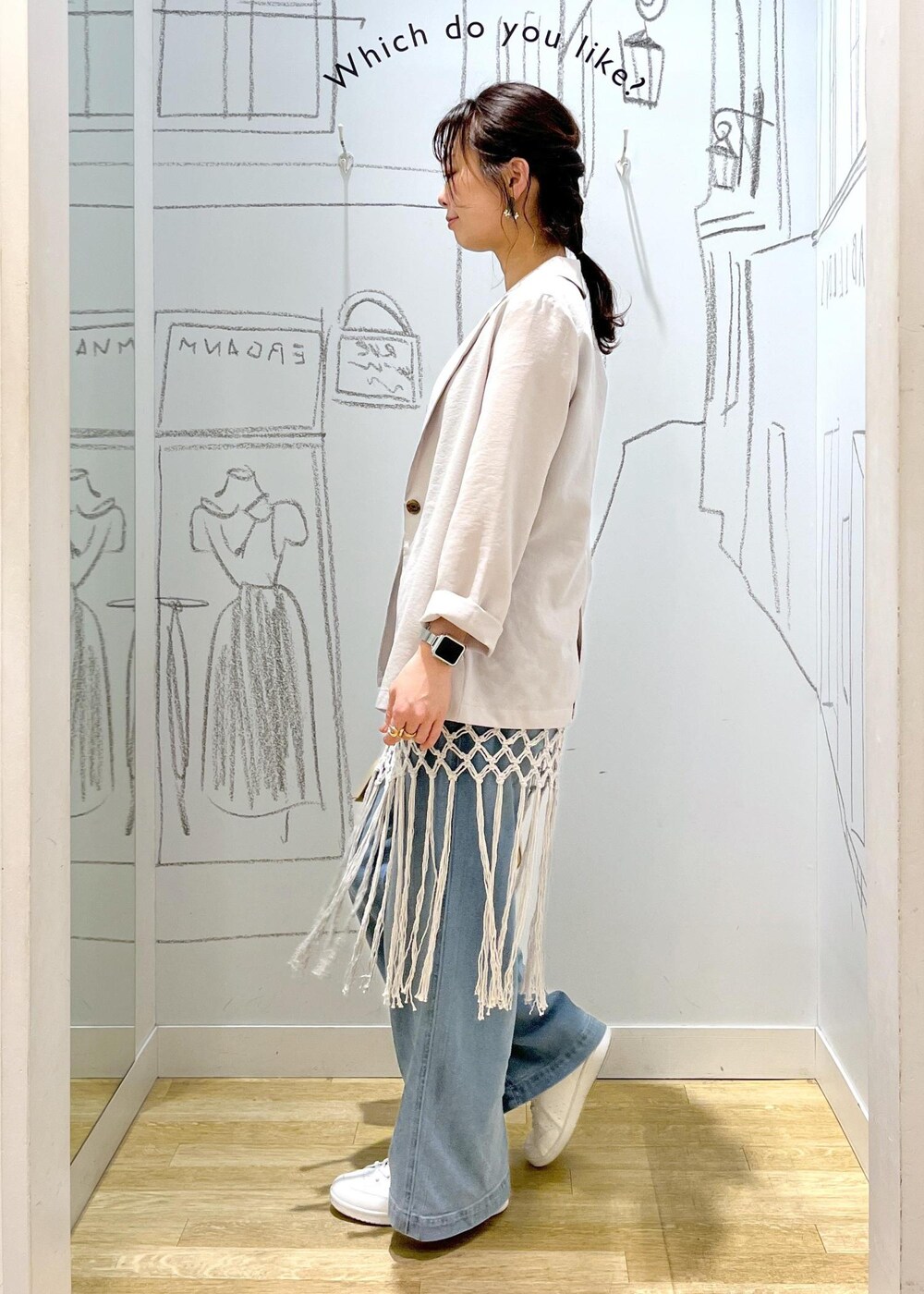 ベージュ系のハンドバッグ、ブルー系のデニムパンツ、ホワイト系のスカートを着用したレディースの春コーディネートの6枚目の写真