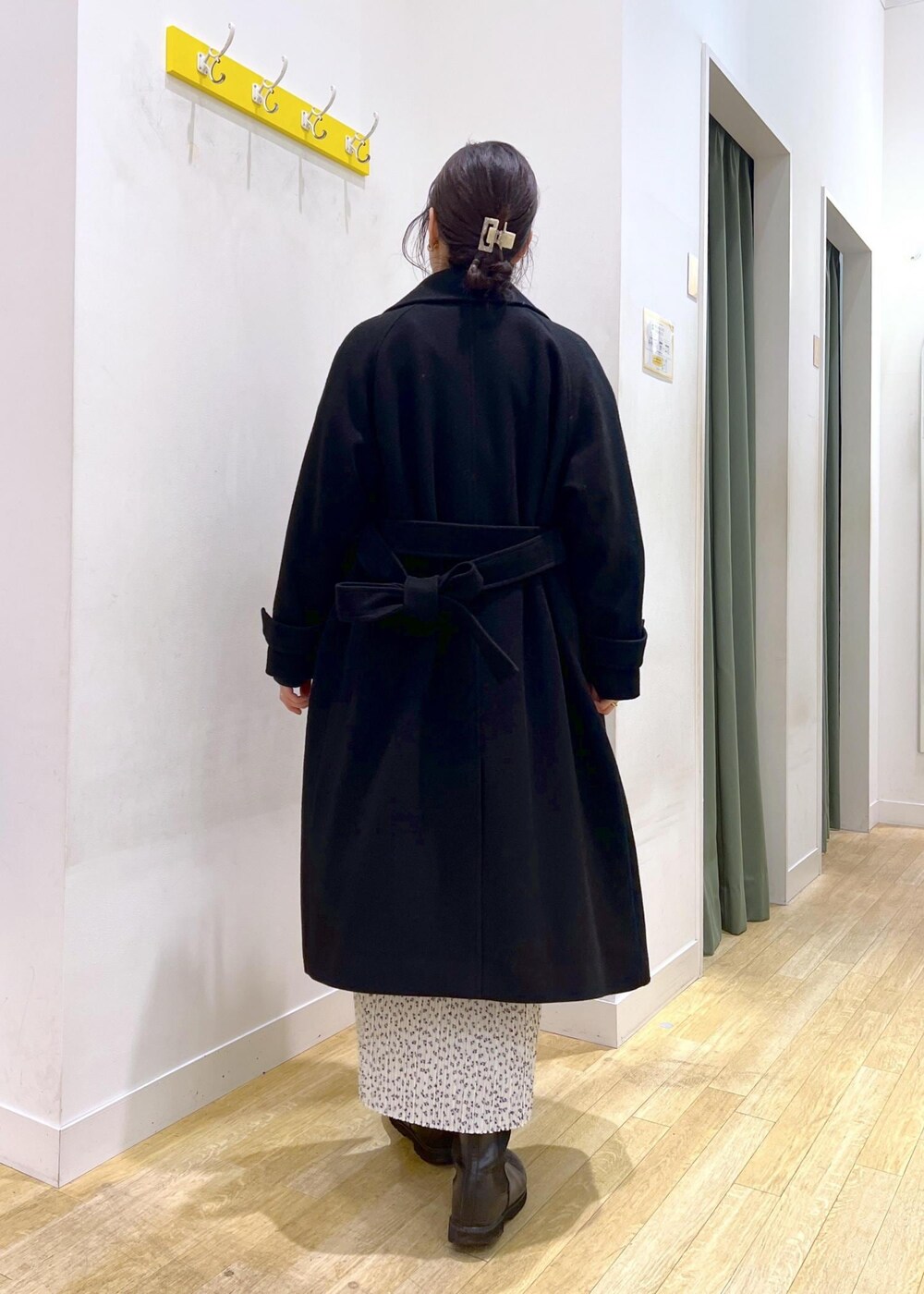 ブラック系のニット/セーター、グレー系のショルダーバッグ、ホワイト系のスカートを着用したレディースの冬コーディネートの2枚目の写真