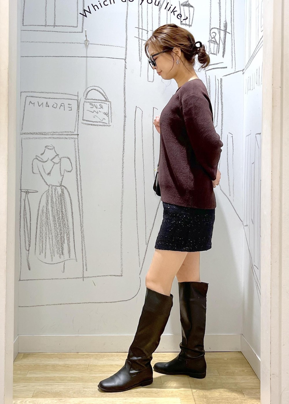 ブラック系のショルダーバッグ、ブラウン系のニット/セーター、ブラック系のダウンジャケット/コートを着用したレディースの冬コーディネートの3枚目の写真