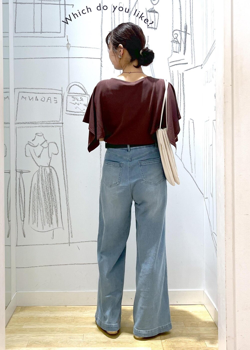 ホワイト系のトートバッグ、ブルー系のデニムパンツ、ブラウン系のニット/セーターを着用したレディースの春コーディネートの6枚目の写真