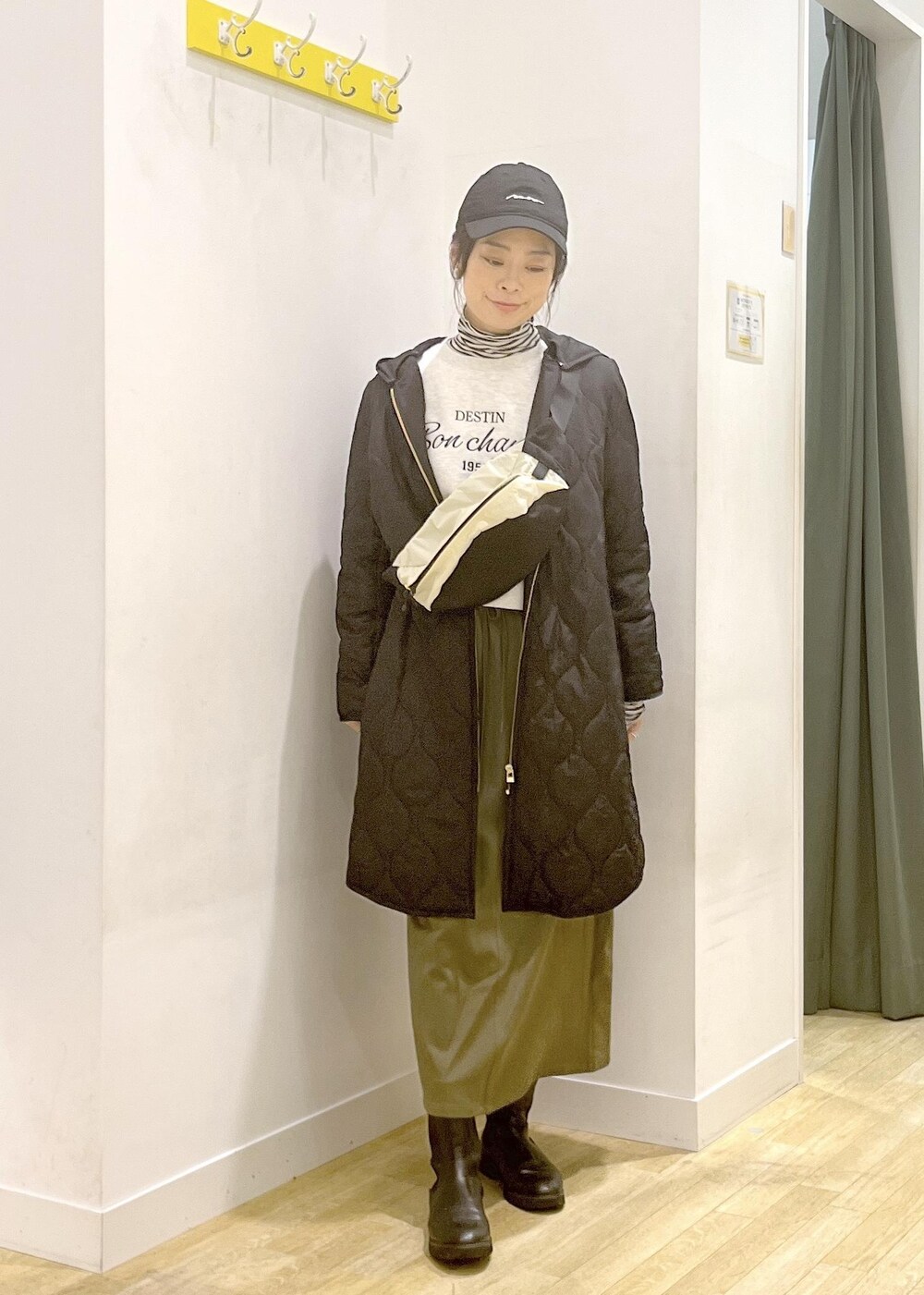 ホワイト系のTシャツ/カットソー、ベージュ系のボディバッグ/ウエストポーチ、ブラック系のその他アウターを着用したレディースの冬コーディネートの2枚目の写真