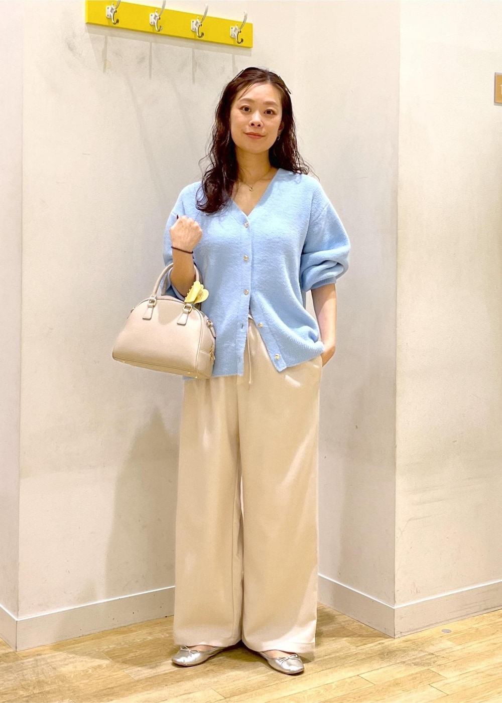ホワイト系のその他パンツ、ブルー系のカーディガン/ボレロ、ベージュ系のボストンバッグを着用したレディースの秋コーディネートの6枚目の写真