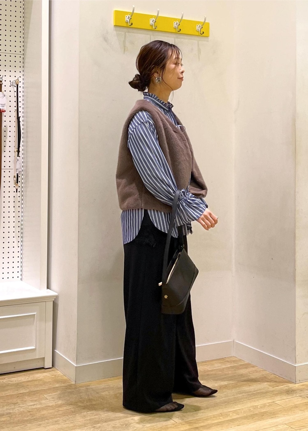 ブラック系のその他パンツ、ブラック系のショルダーバッグ、ブラウン系のベストを着用したレディースの秋コーディネートの2枚目の写真
